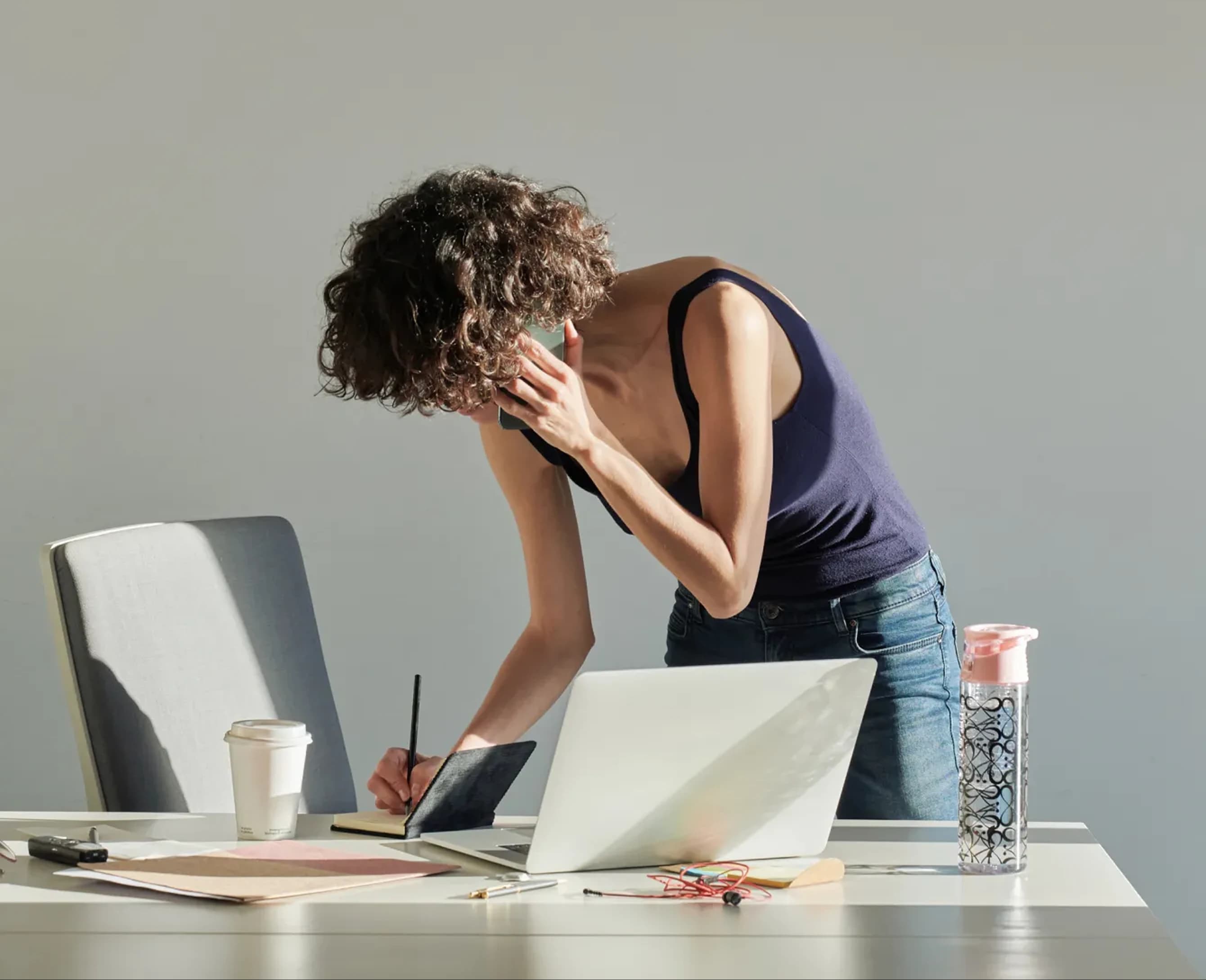 A woman standing and working at a desk